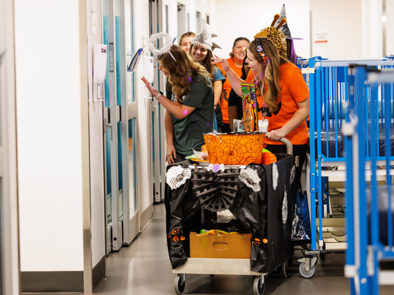 School of Pharmacy student Ansley Hayes, left, and child life specialist Madeline Wilson lead the way, offering Halloween games and treats to Children's of Mississippi patients Monday morning.